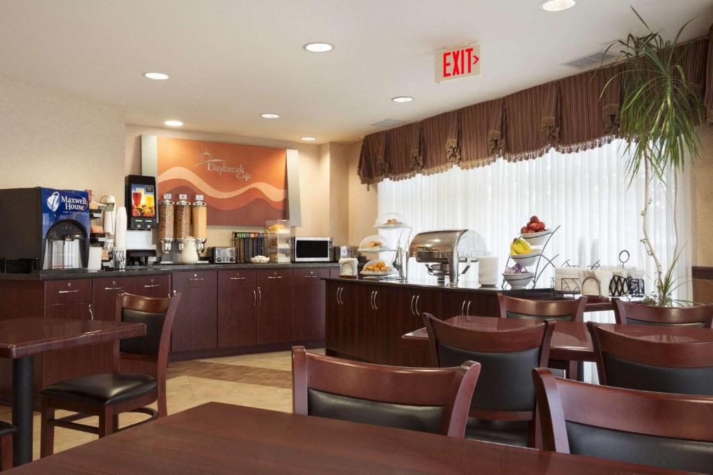 a restaurant with tables and chairs and a bar at Days Inn & Suites by Wyndham Langley in Langley