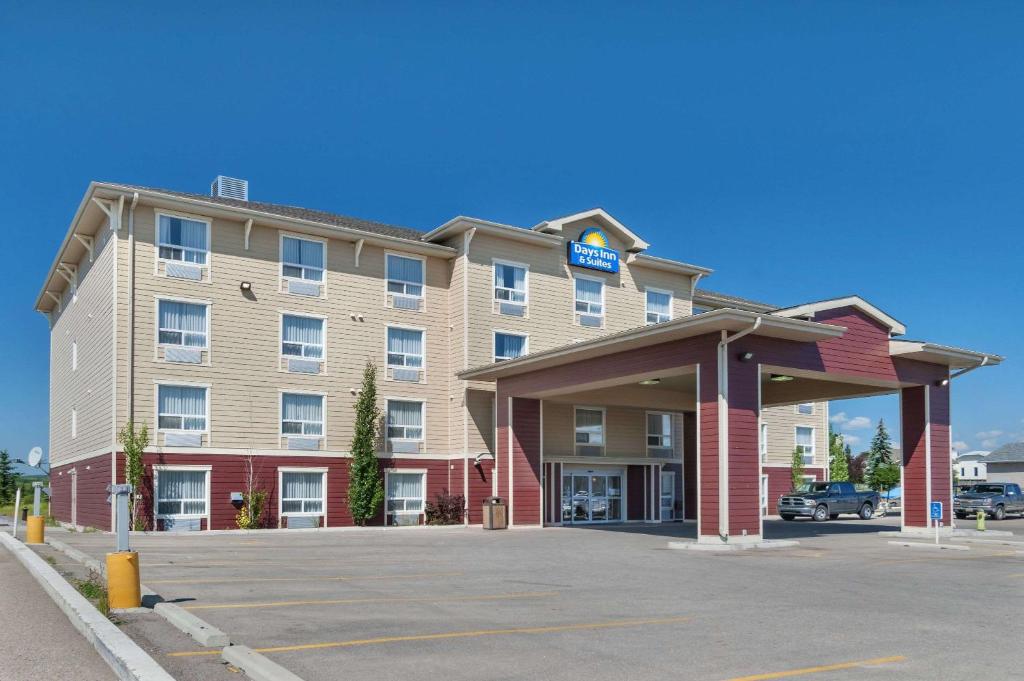 a hotel with a parking lot in front of it at Days Inn & Suites by Wyndham Cochrane in Cochrane