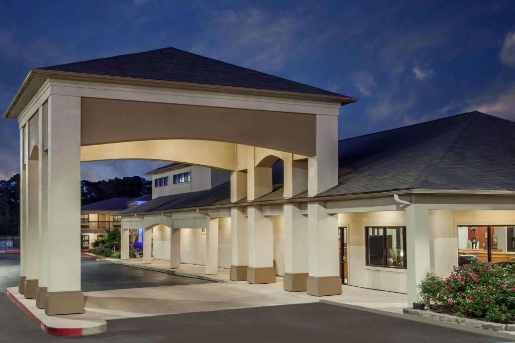 un gran edificio con un arco en un aparcamiento en Days Inn & Suites by Wyndham Huntsville en Huntsville