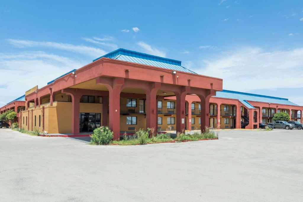 a large red building in a parking lot at Days Inn by Wyndham Midland in Midland