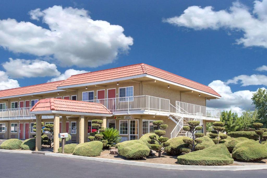 a large building with a balcony on top of it at Days Inn by Wyndham Turlock in Turlock