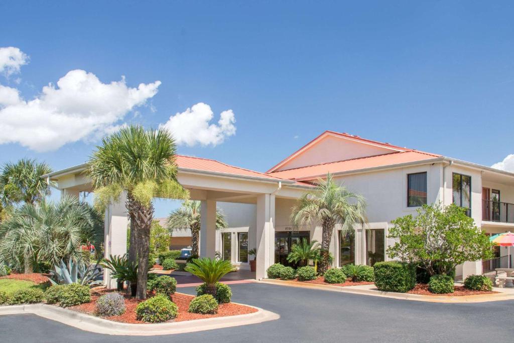 un hotel con palmeras delante en Days Inn & Suites by Wyndham Navarre - near Beaches Hurlburt, en Navarre