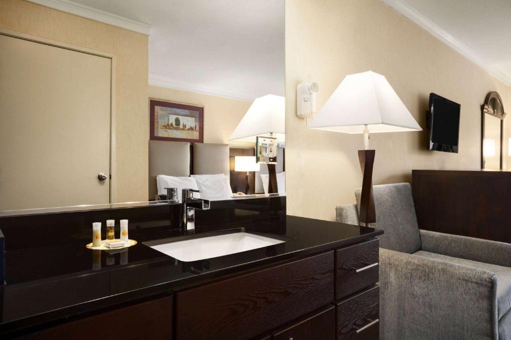 a hotel room with a sink and a mirror at Days Inn by Wyndham Concord in Concord