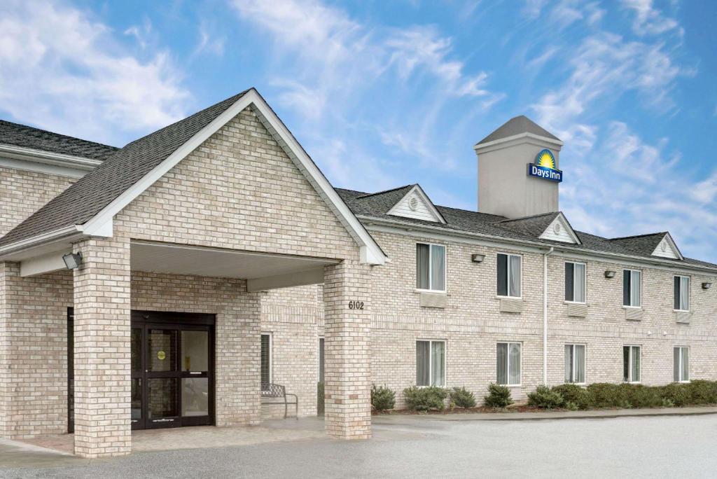 a large brick building with a water tower on top at Days Inn by Wyndham Greensboro NC in Greensboro