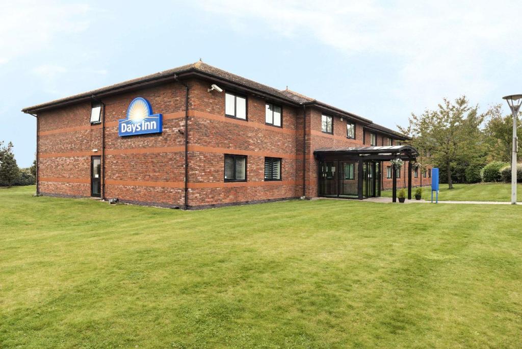 a large brick building with a sign on it at Days Inn Stafford in Stafford