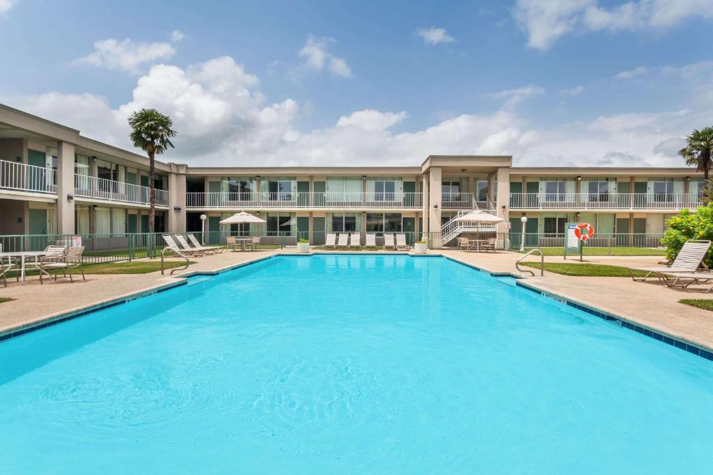 a large swimming pool in front of a building at Days Inn by Wyndham Seguin TX in Seguin