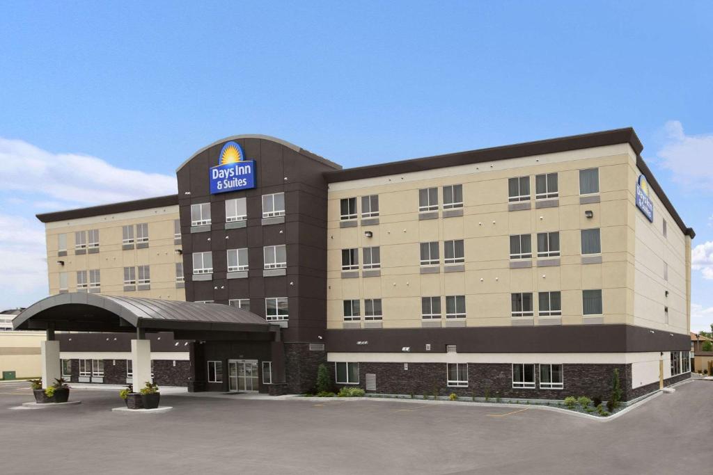 Days Inn & Suites by Wyndham Winnipeg Airport Manitoba في وينيبيغ: مبنى الفندق يوجد عليه لافته