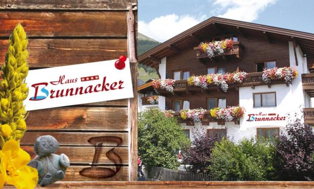 a sign in front of a building with flowers at Haus Brunnacker in Fiss