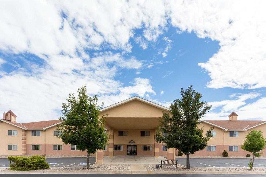 a large building with trees in front of it at Days Inn by Wyndham Colorado Springs Airport in Colorado Springs