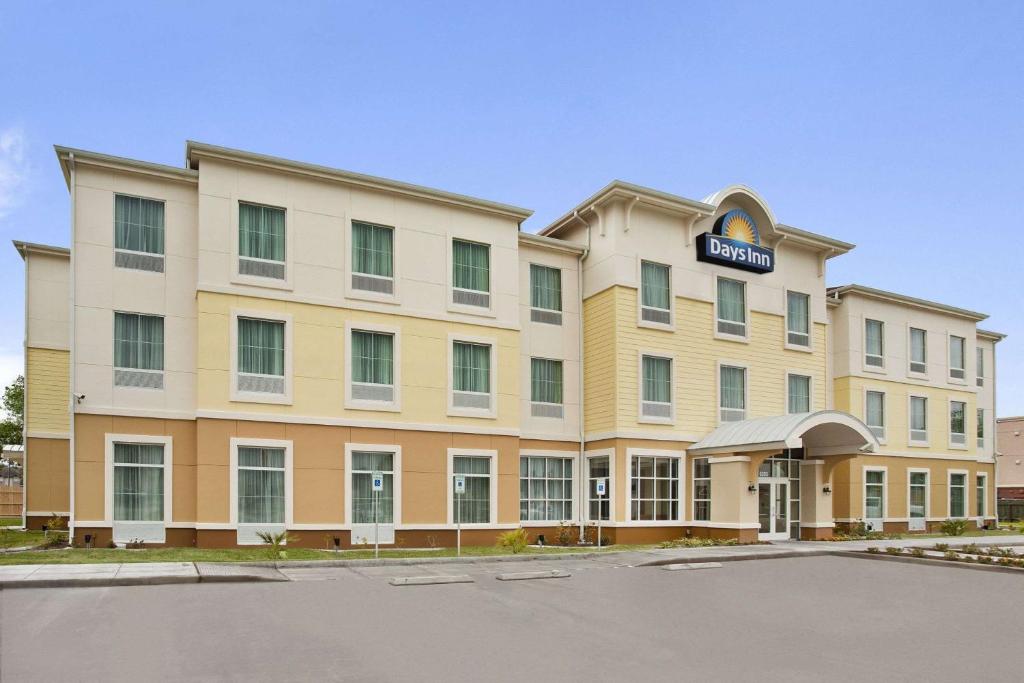 a hotel building with a sign on the front of it at Days Inn by Wyndham Victoria in Victoria