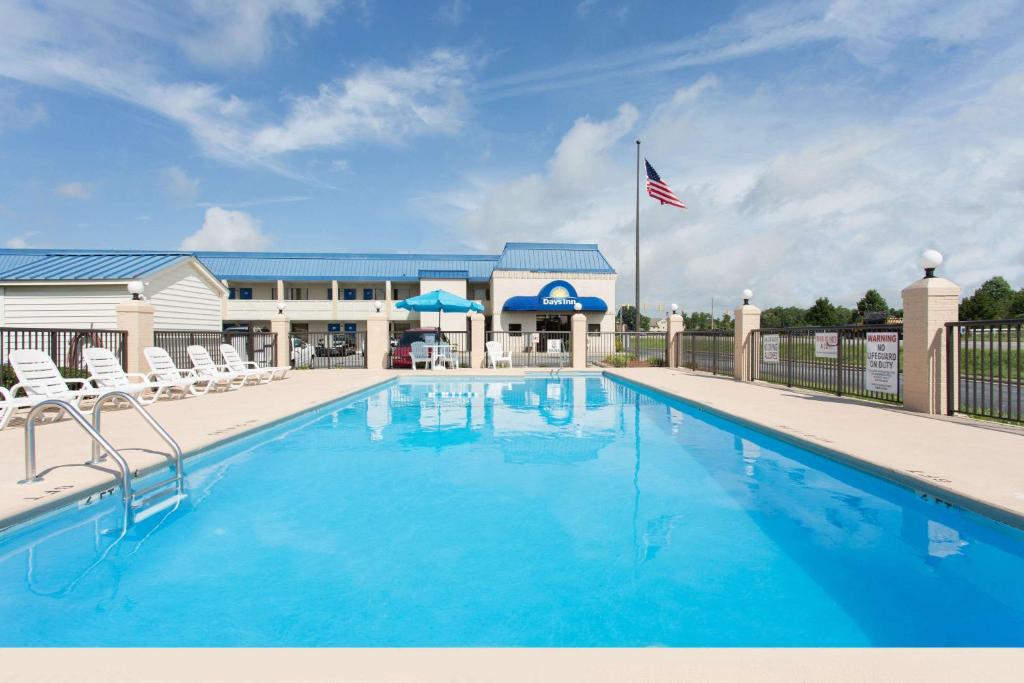 einen Pool mit Stühlen und einer amerikanischen Flagge in der Unterkunft Days Inn by Wyndham High Point/Archdale in Archdale