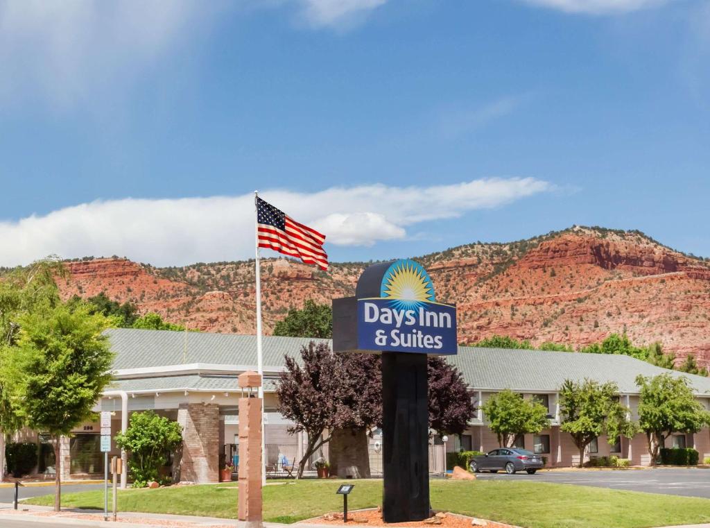 una señal para días posada y suites con bandera americana en Days Inn & Suites by Wyndham Kanab, en Kanab