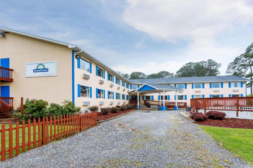 un edificio con una valla delante en Days Inn by Wyndham Chincoteague Island, en Chincoteague