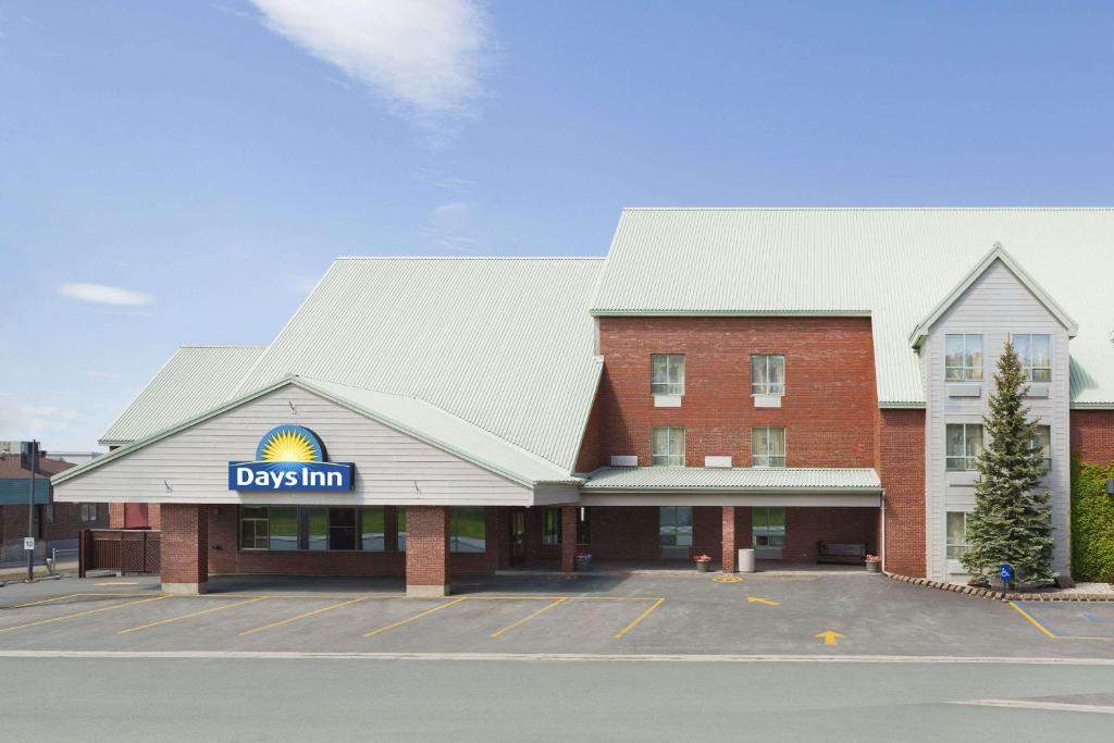 a large brick building with a day inn sign on it at Days Inn by Wyndham Dalhousie in Dalhousie