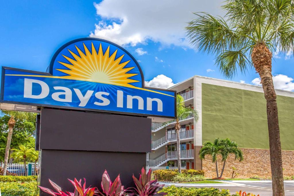 una señal para una posada de día con una palmera en Days Inn by Wyndham Fort Lauderdale Airport Cruise Port, en Fort Lauderdale