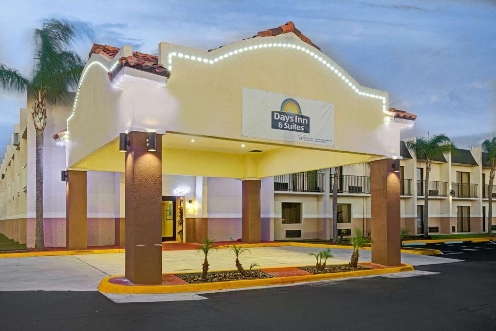 坦帕的住宿－Days Inn & Suites by Wyndham Tampa - Ybor City，一座酒店大楼,前面有标志