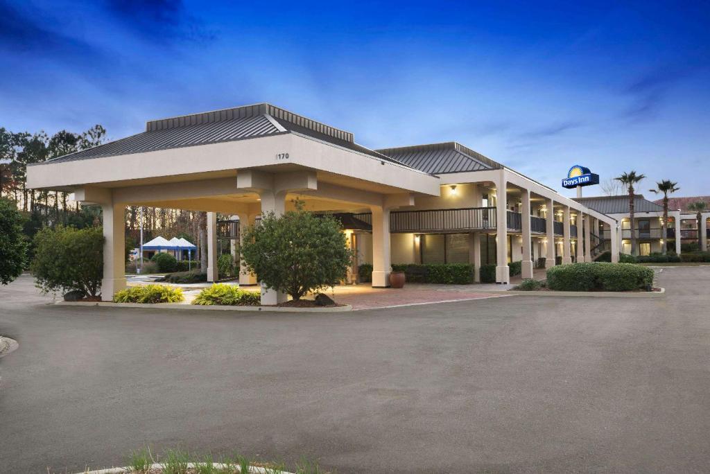 um hotel com um parque de estacionamento em frente em Days Inn by Wyndham Jacksonville Airport em Jacksonville