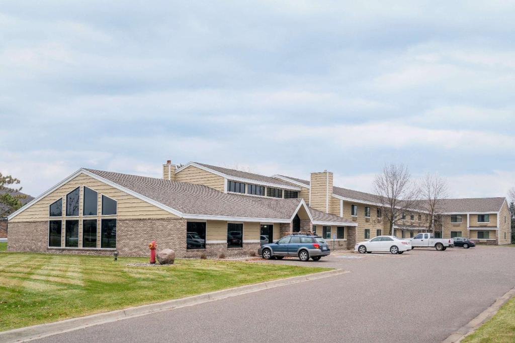 un edificio con coches estacionados en un estacionamiento en Days Inn & Suites by Wyndham Baxter Brainerd Area, en Baxter