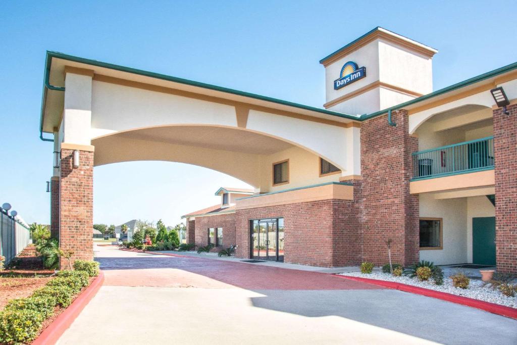 a large brick building with a clock tower on it at Days Inn by Wyndham Baytown East in Baytown