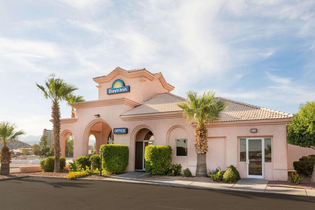 un bâtiment avec des palmiers en face de celui-ci dans l'établissement Days Inn by Wyndham Bullhead City, à Bullhead City