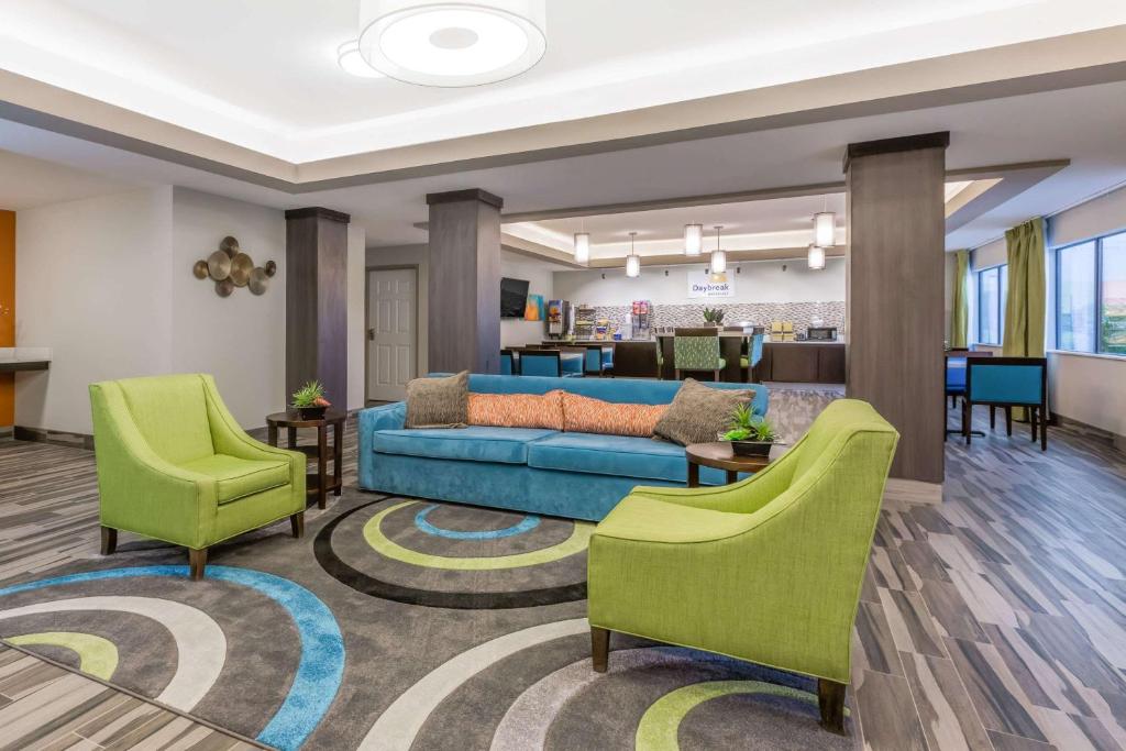 a lobby with a couch and chairs in a room at Days Inn & Suites by Wyndham Katy in Katy