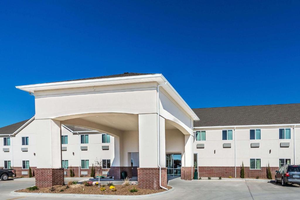 a large white building with an arch in front of it at Days Inn & Suites by Wyndham El Dorado in El Dorado