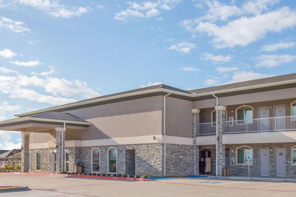 a large building with a balcony on top of it at Days Inn by Wyndham Bryan in Bryan