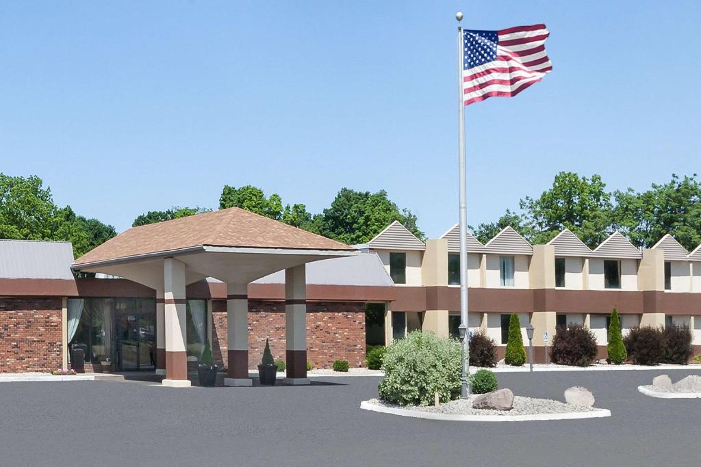 Um edifício com uma bandeira americana à frente. em Days Inn by Wyndham Albion em Albion