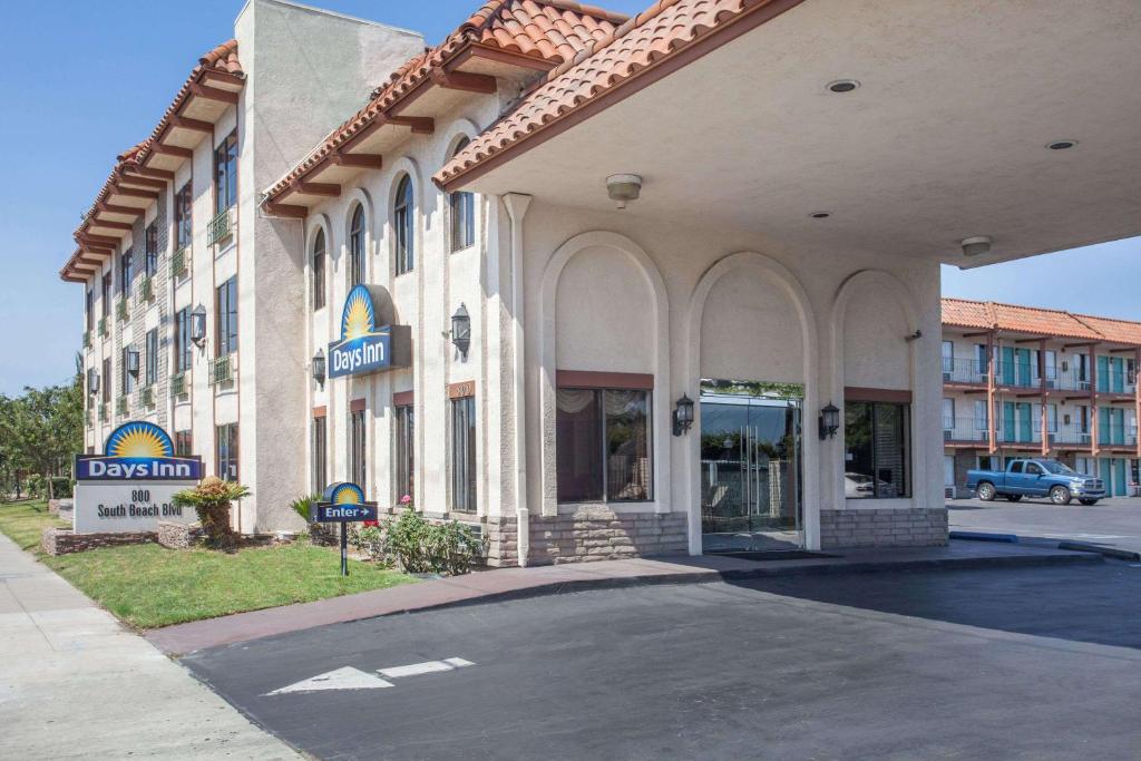 un grand bâtiment avec un panneau devant lui dans l'établissement Days Inn by Wyndham Anaheim Near the Park, à Anaheim