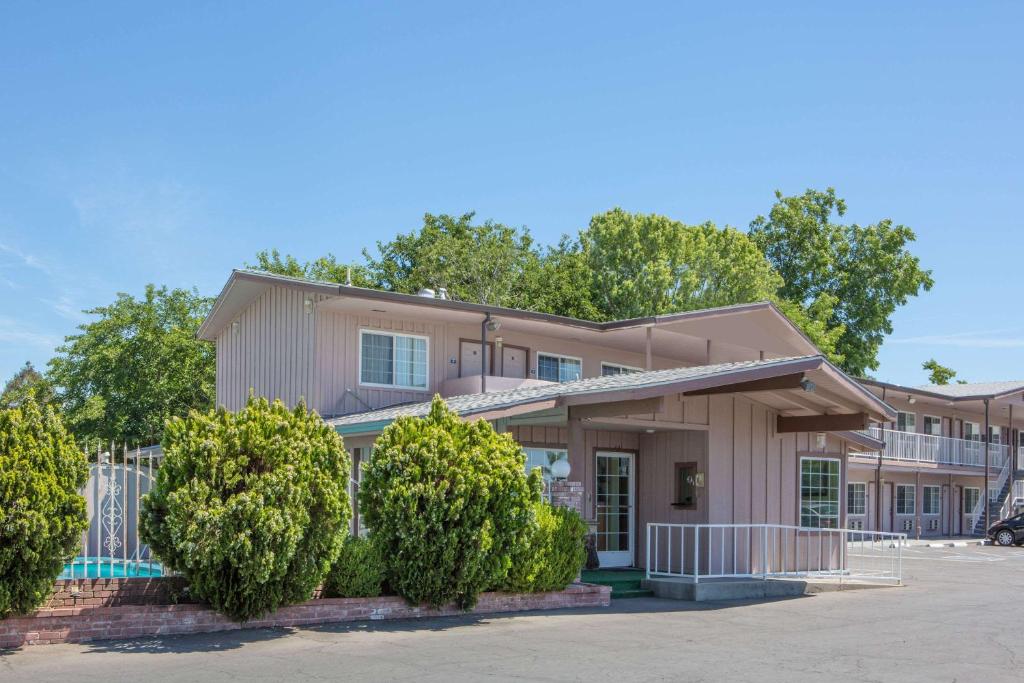 un edificio con árboles delante de él en Days Inn by Wyndham Oroville, en Oroville