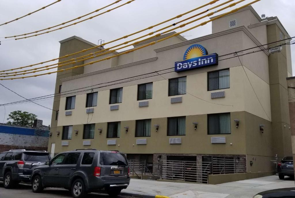 een hotel met auto's voor het hotel bij Days Inn by Wyndham Brooklyn Marine Park in Brooklyn