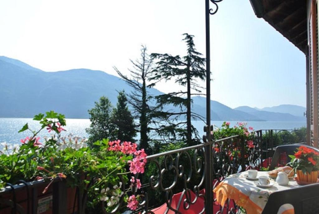 a table with flowers and a view of the water at Casa Farfalla in Cannobio