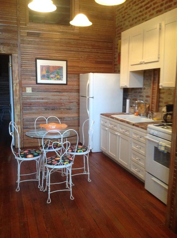 a kitchen with a table and chairs and a refrigerator at The Main Street Hotel in Yazoo City