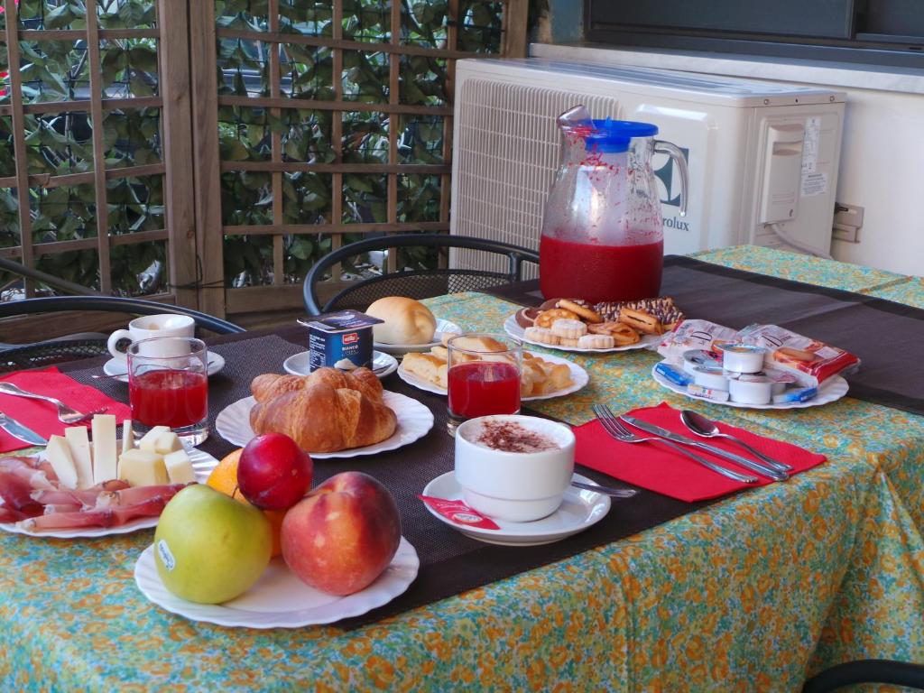 einen Tisch mit Teller mit Lebensmitteln und Obst in der Unterkunft Hotel Europa in Albissola Marina