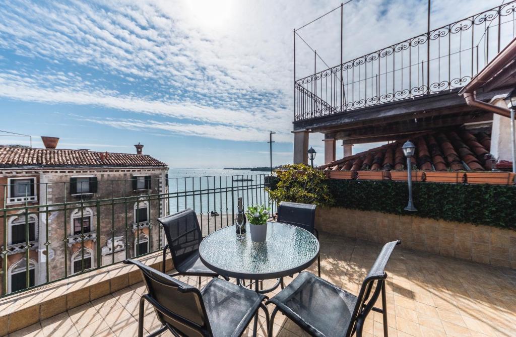 patio con mesa y sillas en el balcón en Ca' Delfina Holiday Home, en Venecia