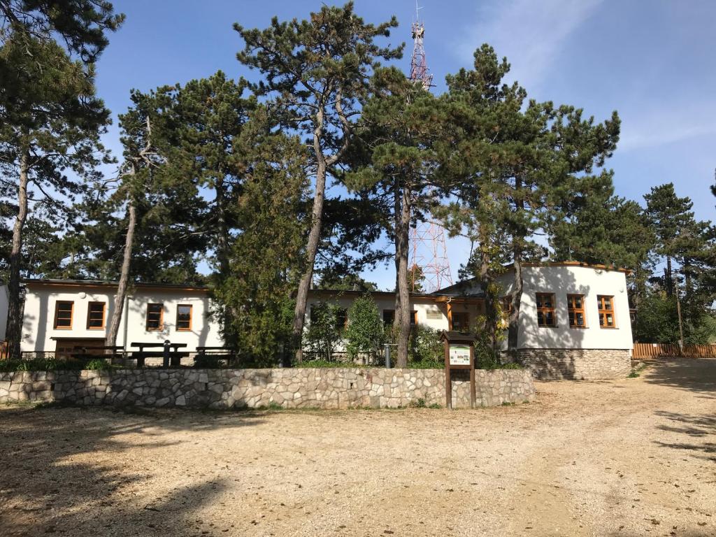 Casa blanca con una pared de piedra y árboles en Rotter Lajos Turistaház en Budapest