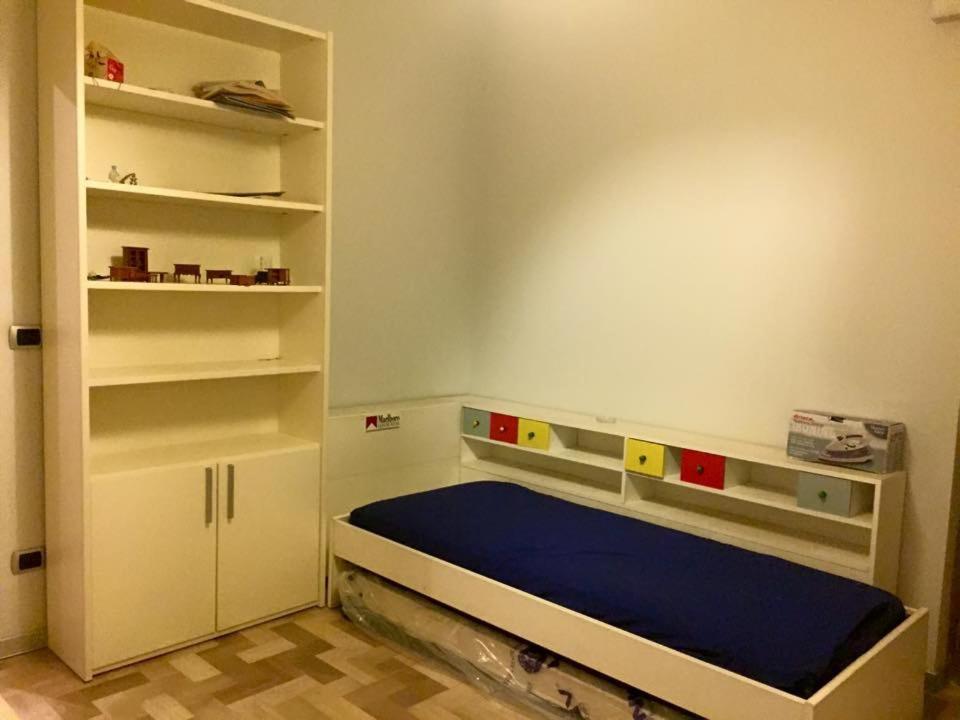 a small room with a bed and shelves at Appartamento verde in Marina di Gioiosa Ionica