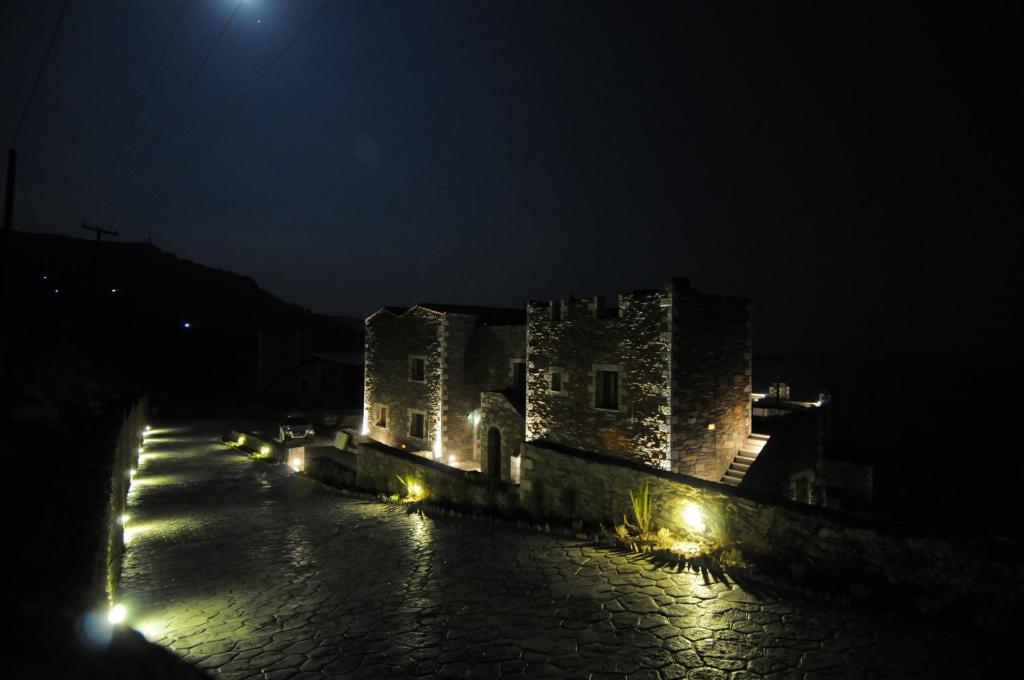 um castelo iluminado à noite com luzes em Porto Mani Suites em Kyparissos