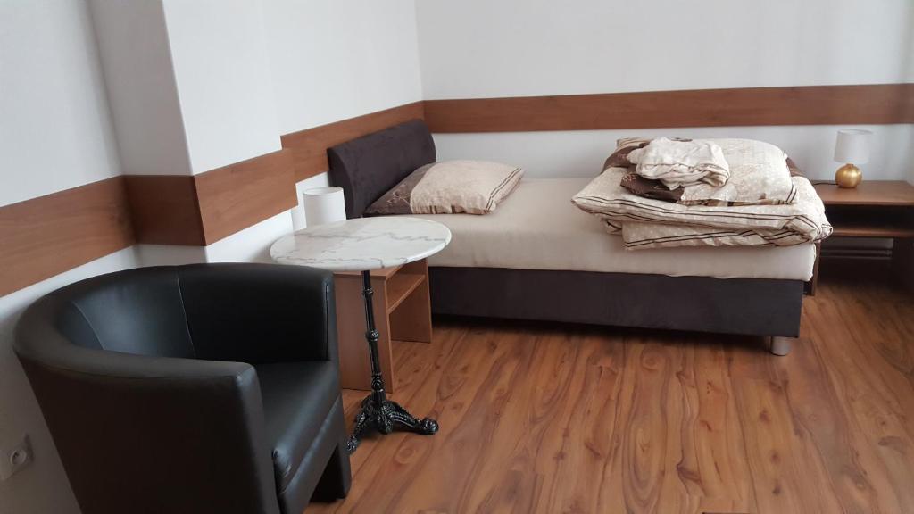 um pequeno quarto com uma cama e uma cadeira em Penzion 324 em Štoky