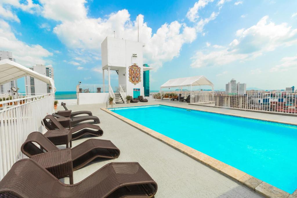 a pool on the rooftop of a building with lounge chairs at Hotel Faranda Express Soloy & Casino in Panama City