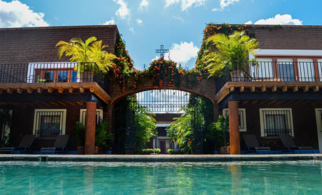 a swimming pool in front of a building with plants at Casa Pixan in Malinalco