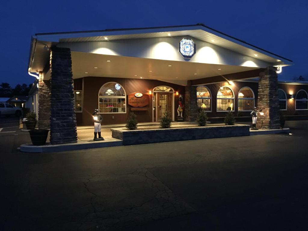 a person standing in front of a restaurant at night at Landmark Motor Inn in Glens Falls