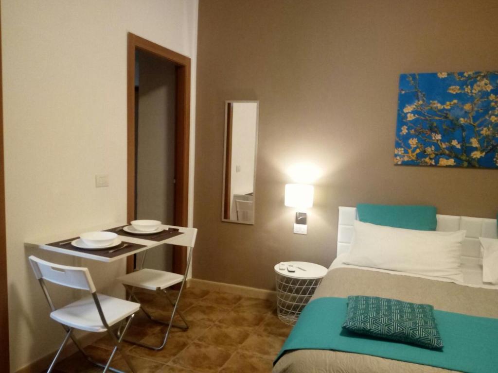 una camera con letto, tavolo e sedie di Le Suite dei Due Mari cucinino privato a Taranto