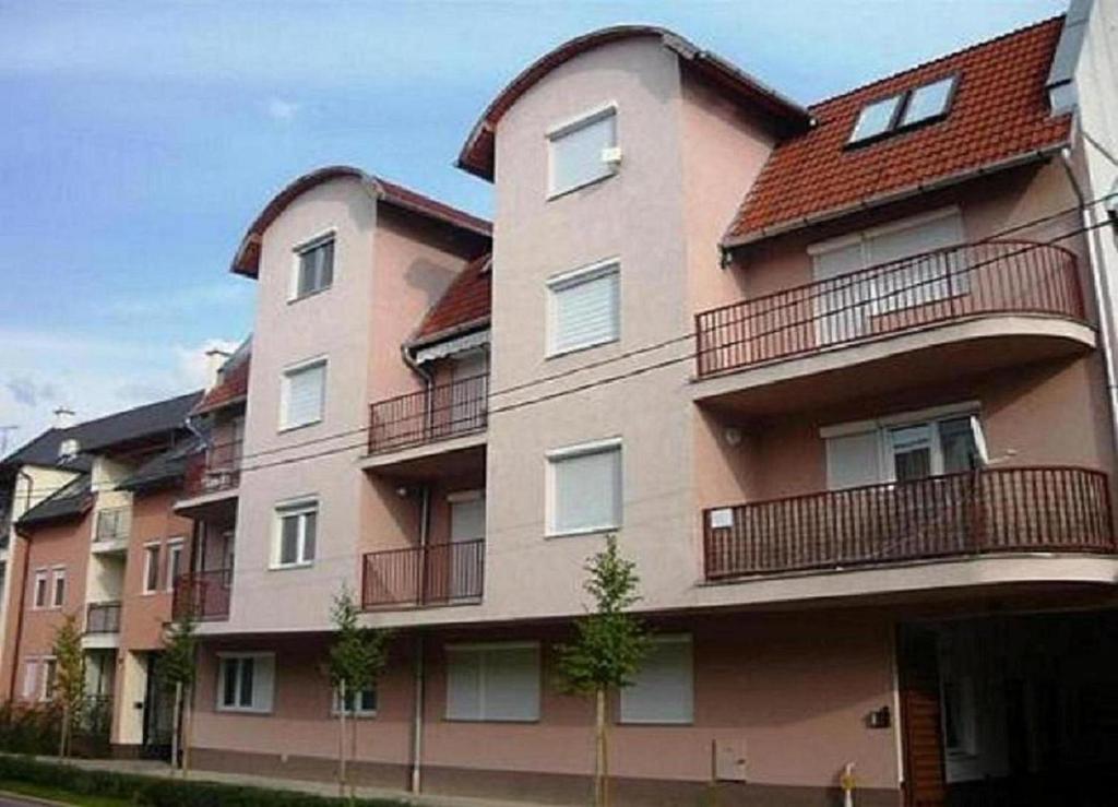 a large building with balconies on the side of it at Margit Apartman in Hajdúszoboszló