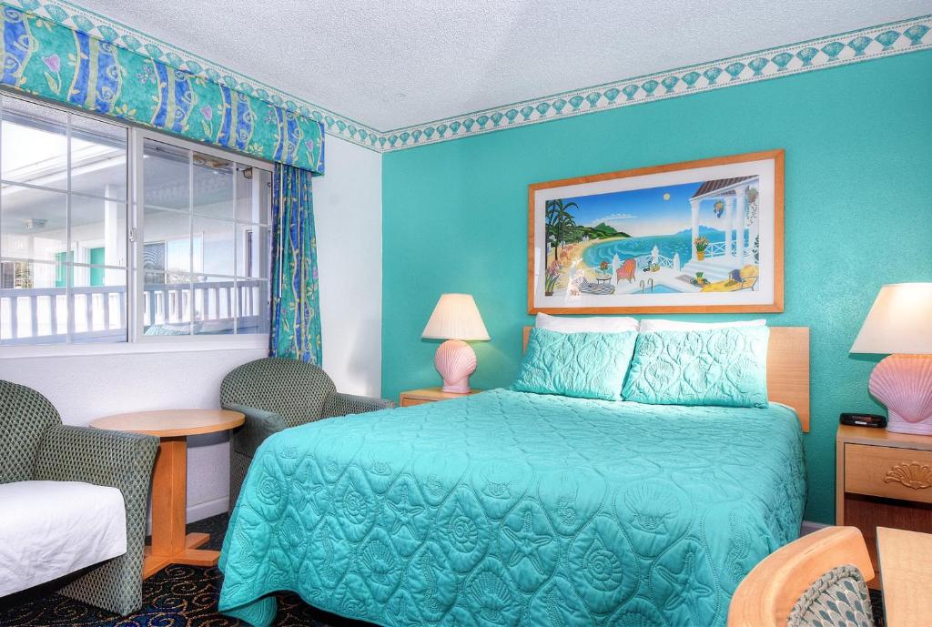 a blue bedroom with a bed and a window at Morro Bay Sandpiper Inn in Morro Bay