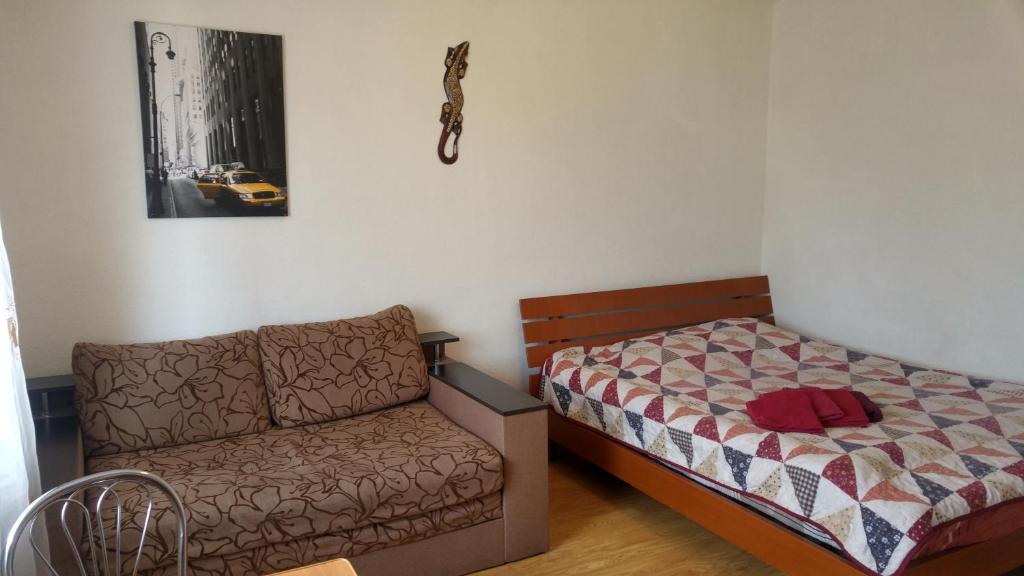 キーウにあるbul. Lesi ukrainki 3のソファとベッドが備わるベッドルーム1室、