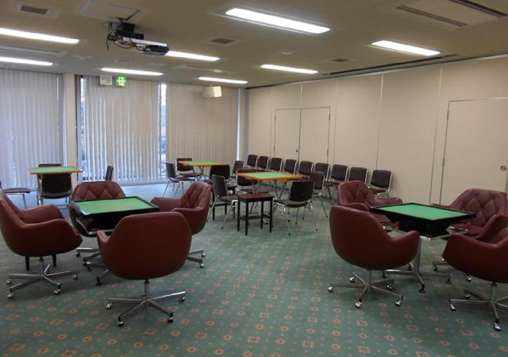 une salle de conférence avec des tables et des chaises dans l'établissement Hotel New Momiji, à Nasushiobara