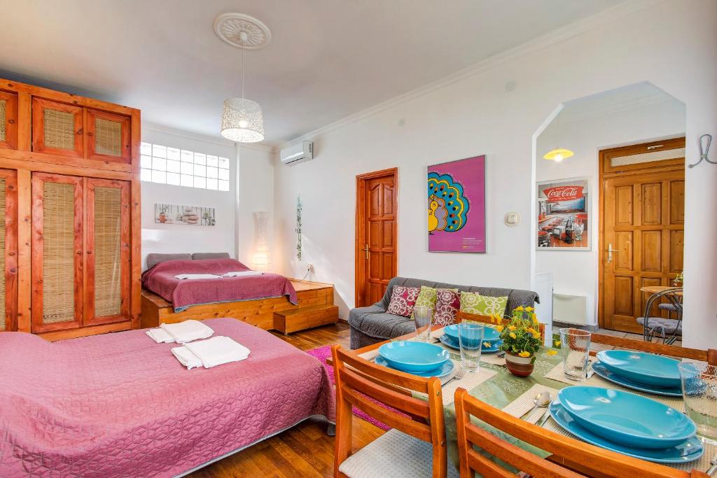 uma sala de estar com 2 camas e uma mesa de jantar em Apartment near the Heroes Square em Budapeste