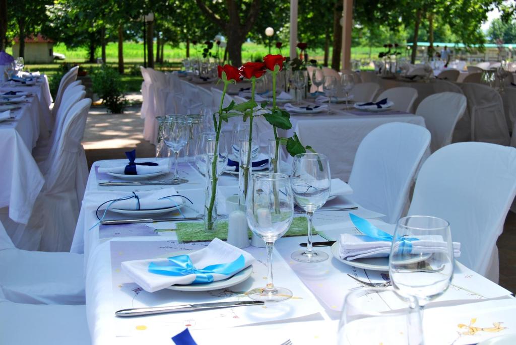 stół z białymi stołami i kieliszkami do wina w obiekcie Yannis Hotel w mieście Krinídhes