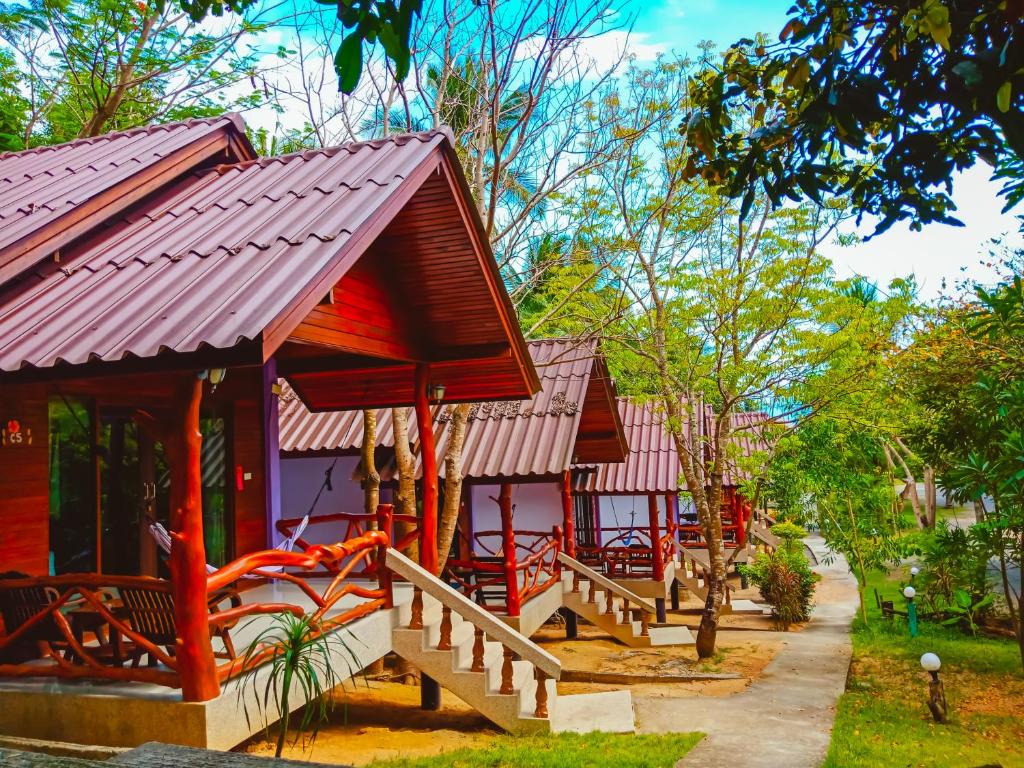 a group of buildings with red roofs and a playground at Ban Tai Resort in Baan Tai